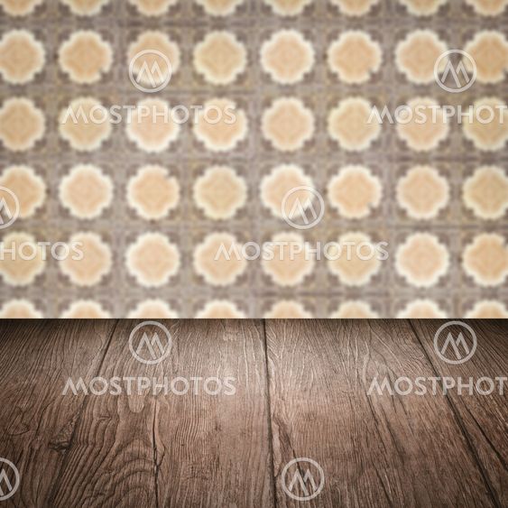 Wood table top and blur vintage ceramic tile pattern wall