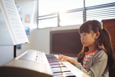 Concentrated girl practicing piano in class