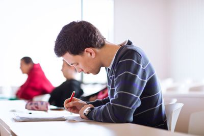 young, handsome male college student sitting in a...