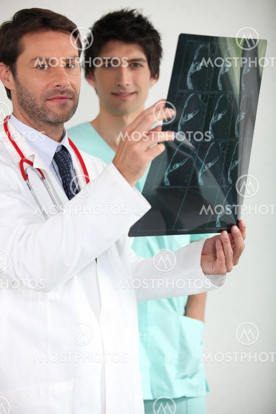 Doctor and male nurse examining x-ray image