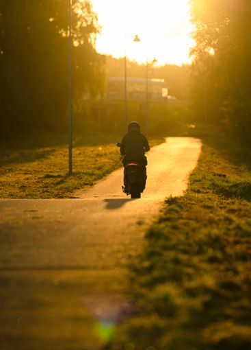 Moped on the way to work in morning light.