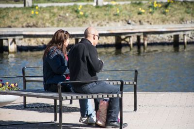ett par sitter utomhus på en parkbänk