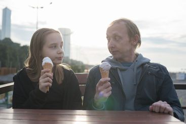 Father and daughter enjoying ice cream together, family...