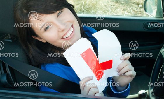 Cheerful young female driver tearing up her L sign