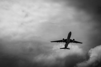 Commercial airplane on grey sky and clouds with copy...