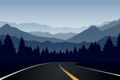 road curve in forest and mountain landscape at dawn