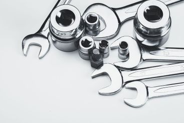 Various metal tools arranged neatly on a light surface...