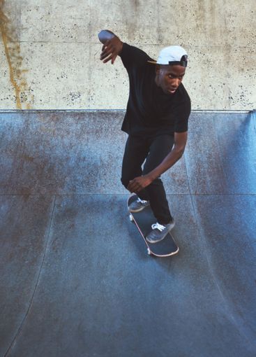 Urban, skateboard and ramp with black man at park for...