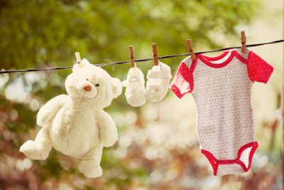 Baby clothes and teddy bear hanging on the clothesline