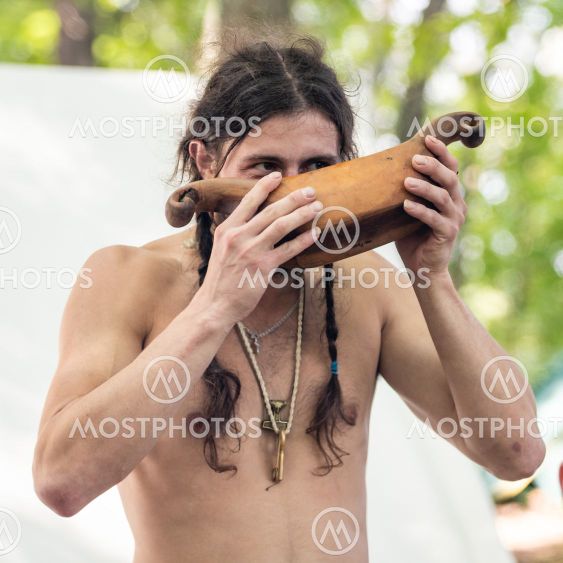Young viking drinks from a wooden bowl