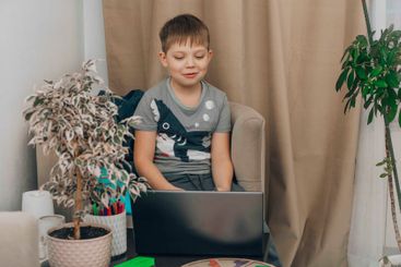 Kid concentrating on a laptop, representing the balance...
