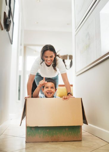 Box, moving house and mother pushing son for having fun...