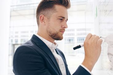 Business, writing and man in office, whiteboard and...