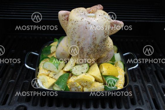 beer butt chicken on the grill with veggies