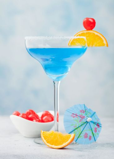 Blue lagoon summer cocktail in margarita glass with...