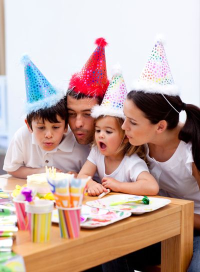 Little girl blowing out candles in her birthday's day...