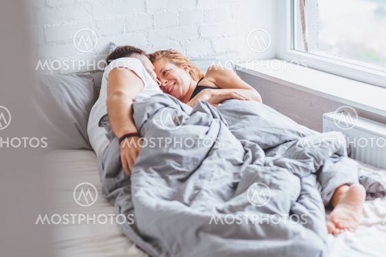 Young couple enjoying bed time in the morning