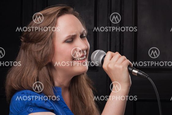 Girl singing to the microphone in a studio