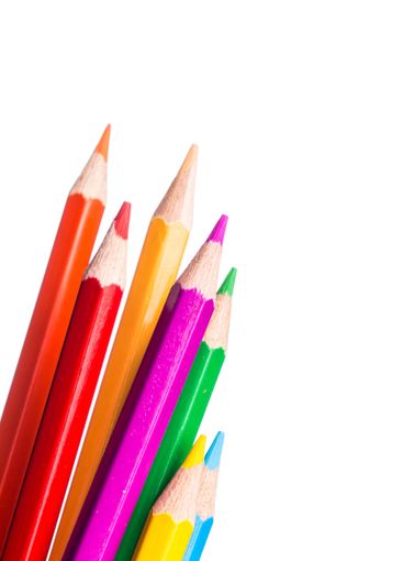Bright colored pencils arranged together on a white...
