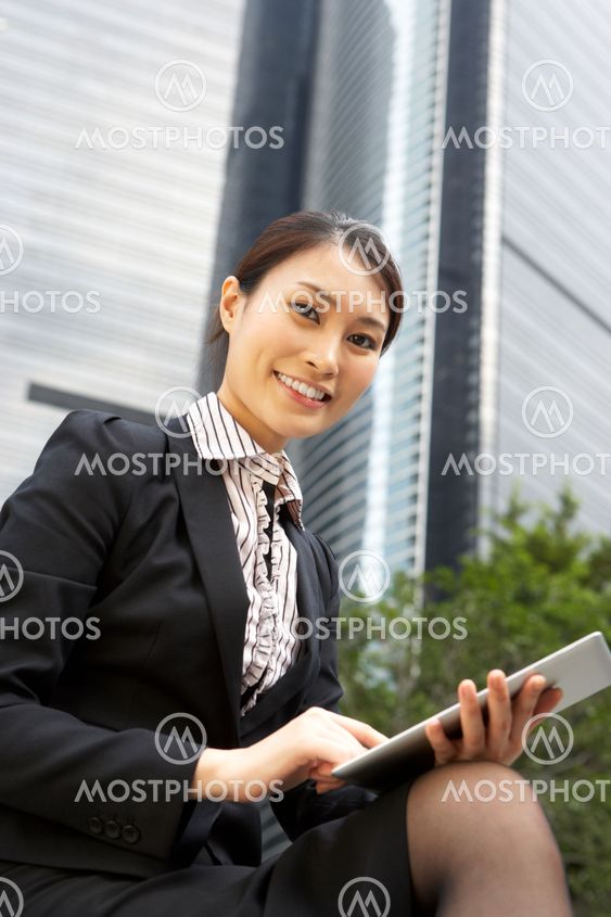 Chinese Businesswoman Working On Tablet Computer Outside Office