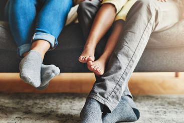 Legs, family and relax in living room, home and parents...