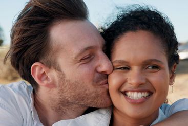 Kiss, love and smile with couple at beach for travel...