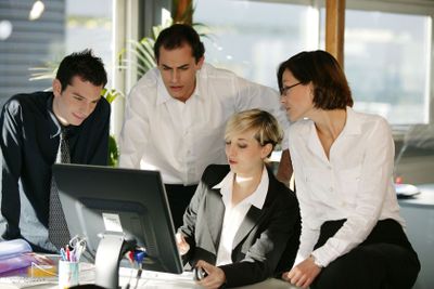 Business team gathered around computer