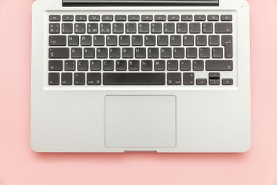 Keyboard laptop computer isolated on pink pastel desk...