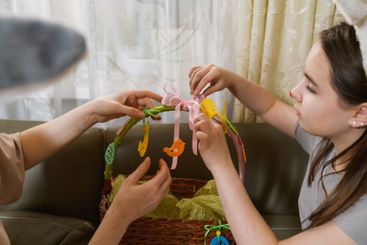 Mother and daughter decorating an Easter basket together.
