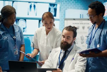 Healthcare professionals examine human anatomy scans to...