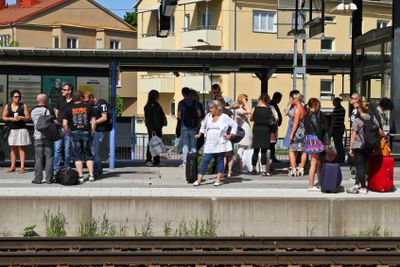 Resenärer på plattform väntar på tåget