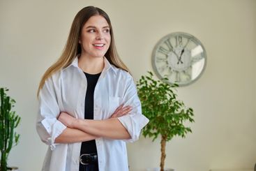 Confident young woman with crossed arms in home interior