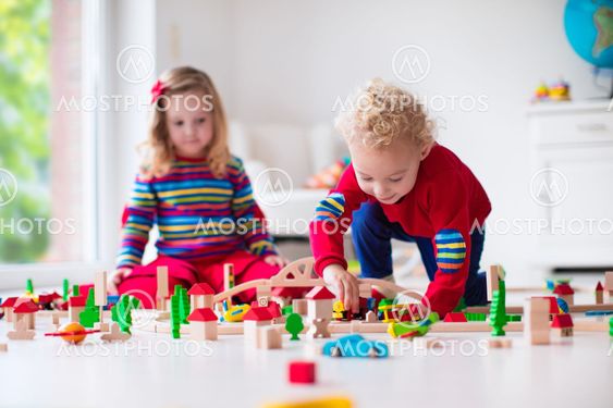 Children playing with toy railroad and train