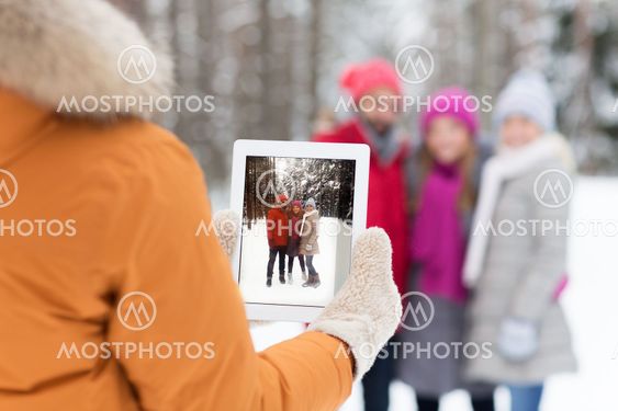 happy friends with tablet pc in winter forest