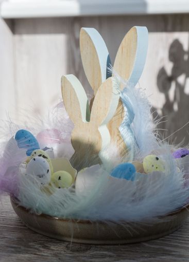 Unrecognizable woman creating Easter holiday decoration...