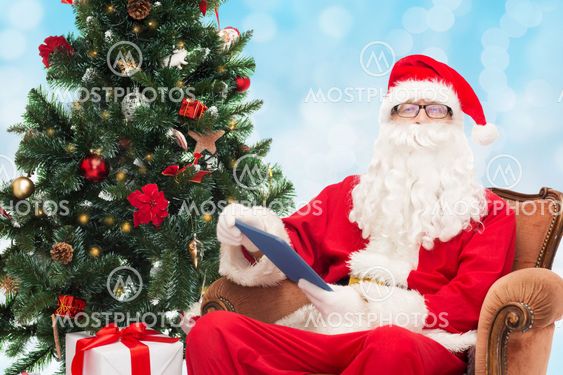 man in costume of santa claus with tablet pc
