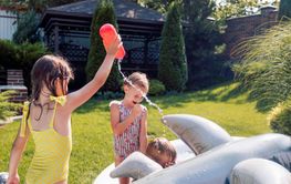 Small children splash water and have fun in the backyard...