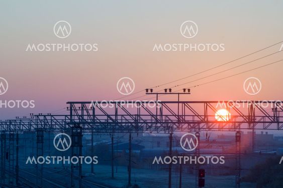 Sun rising on frosty morning over cargo railway station