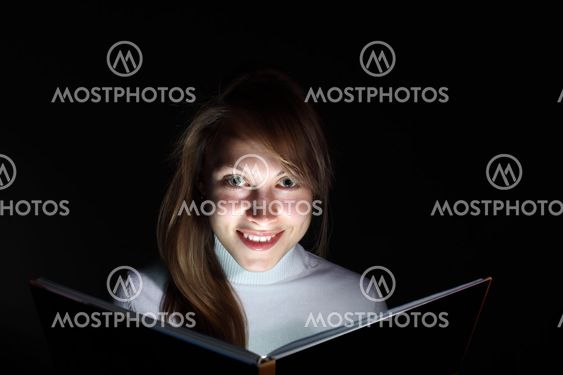 Young woman reading a magic book