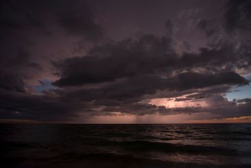 Thunderstorm clouds over rough ocean waters. Evening sea...