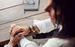 Senior woman holding friend's hand