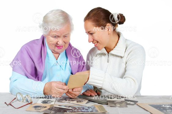 Grandmother with granddaughter looks old family photos.