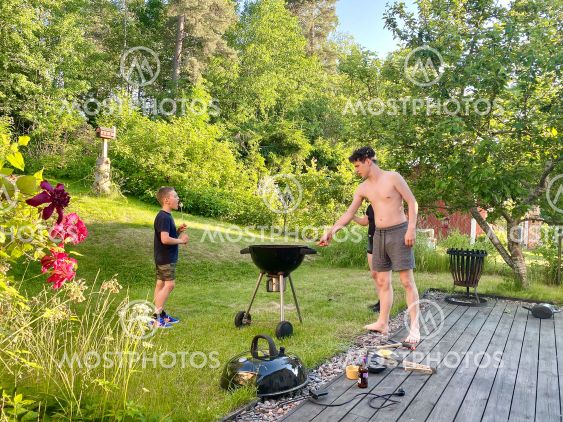 Barn och ungdomar grillar marshmallows i trädgården hemma.
