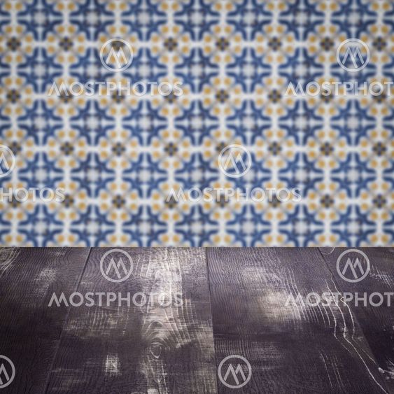 Wood table top and blur vintage ceramic tile pattern wall
