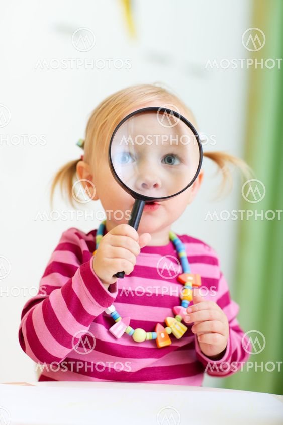 Toddler girl looking through magnifier