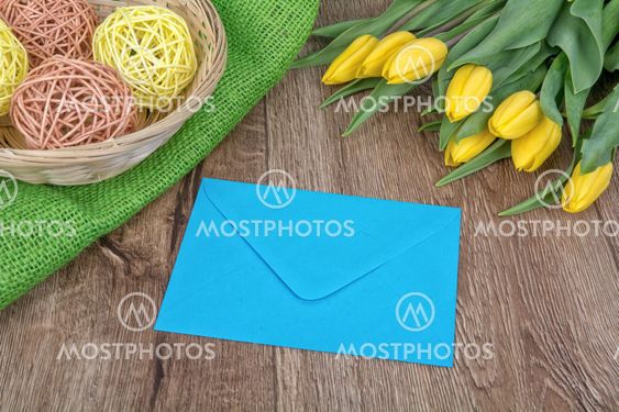 Envelope and tulips on a wooden background