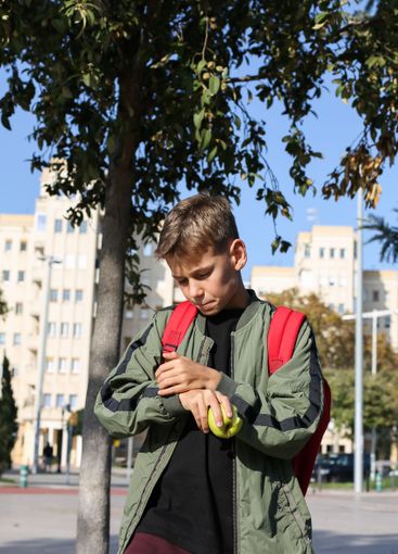 Handsome teenager standing with skateboard. Adolescent...