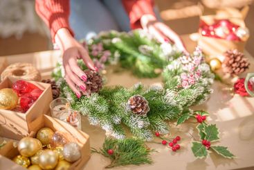 Woman making mistletoe wreath Christmas wreath...