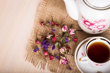 Vintage cup of tea with buds of roses