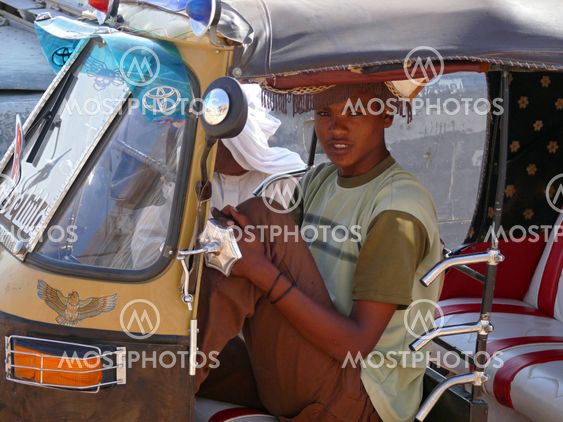 WADI - HALFA, SUDAN - NOVEMBER 19, 2008: An unknown man and a motorcycle taxi driver near an unfamiliar passenger closeup.